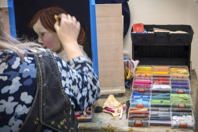 nainen värittää liiduilla muotokuvaa lapsesta