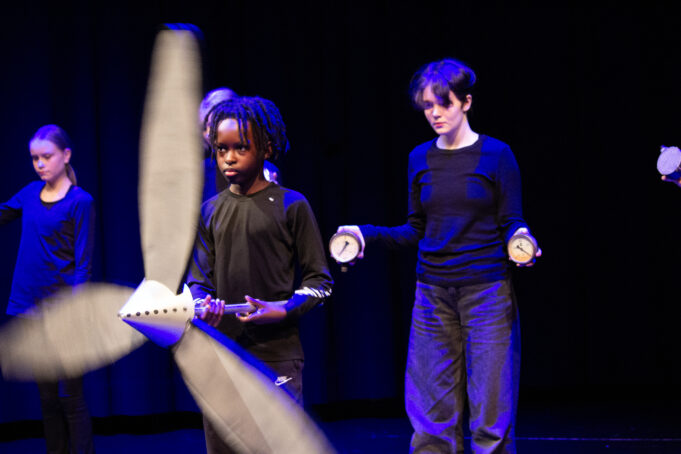 Nuoriateatterinharrastajia lavalla.Yhdellä nuorella kädessään iso propelli