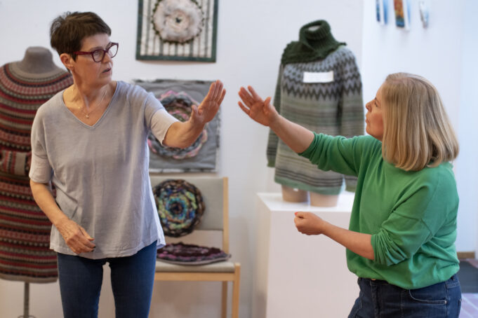 Kaksi naista tekemässä improvisaatioteatteria Kuusankoskitalon galleriassa